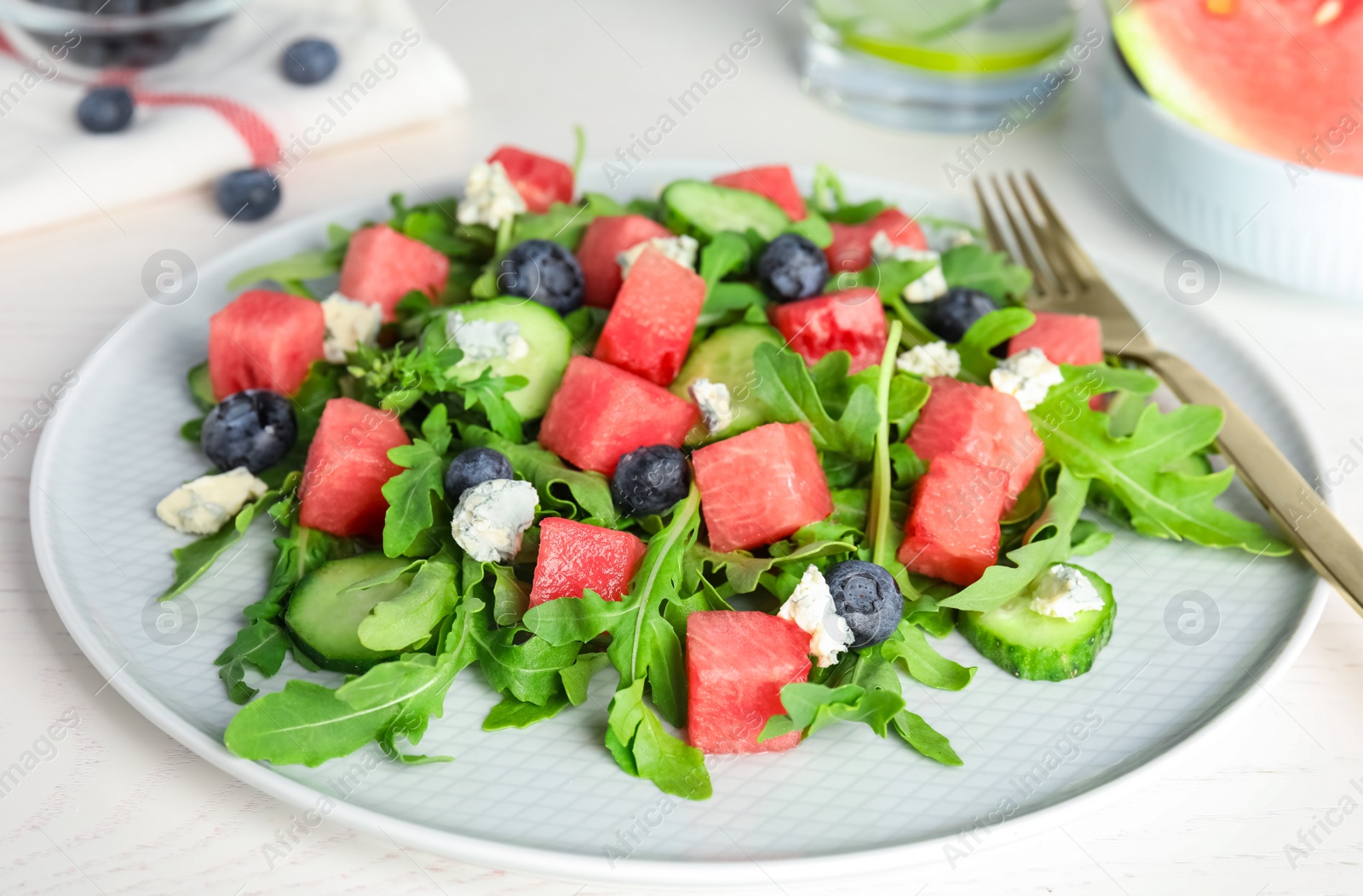 Photo of Delicious salad with watermelon served on white table, closeup