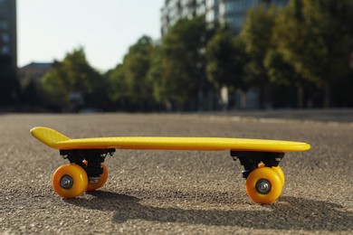 Stylish yellow skate board on asphalt outdoors