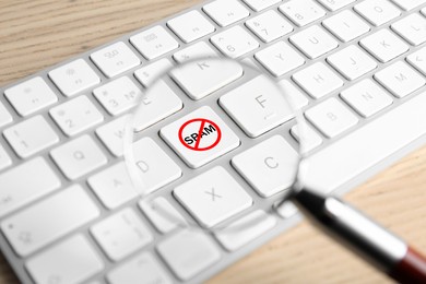 Image of Prohibition sign with word Spam on keyboard button, view through magnifier