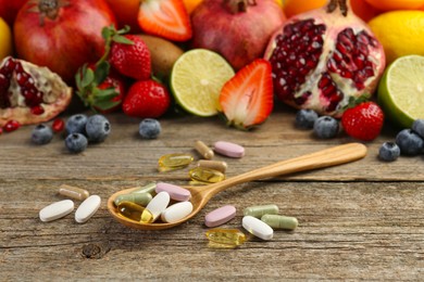 Photo of Different vitamin pills and fresh fruits on wooden table