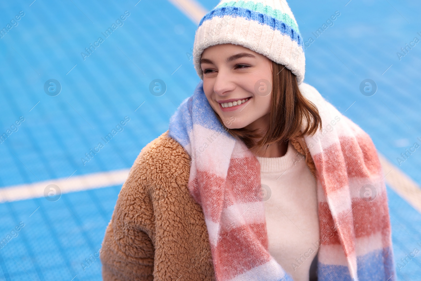 Photo of Beautiful woman in warm scarf and hat outdoors, space for text