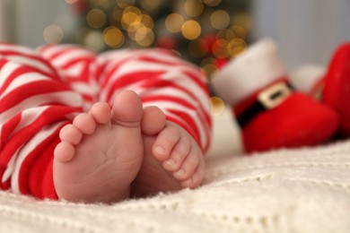 Cute little baby on blanket in room decorated for Christmas, closeup