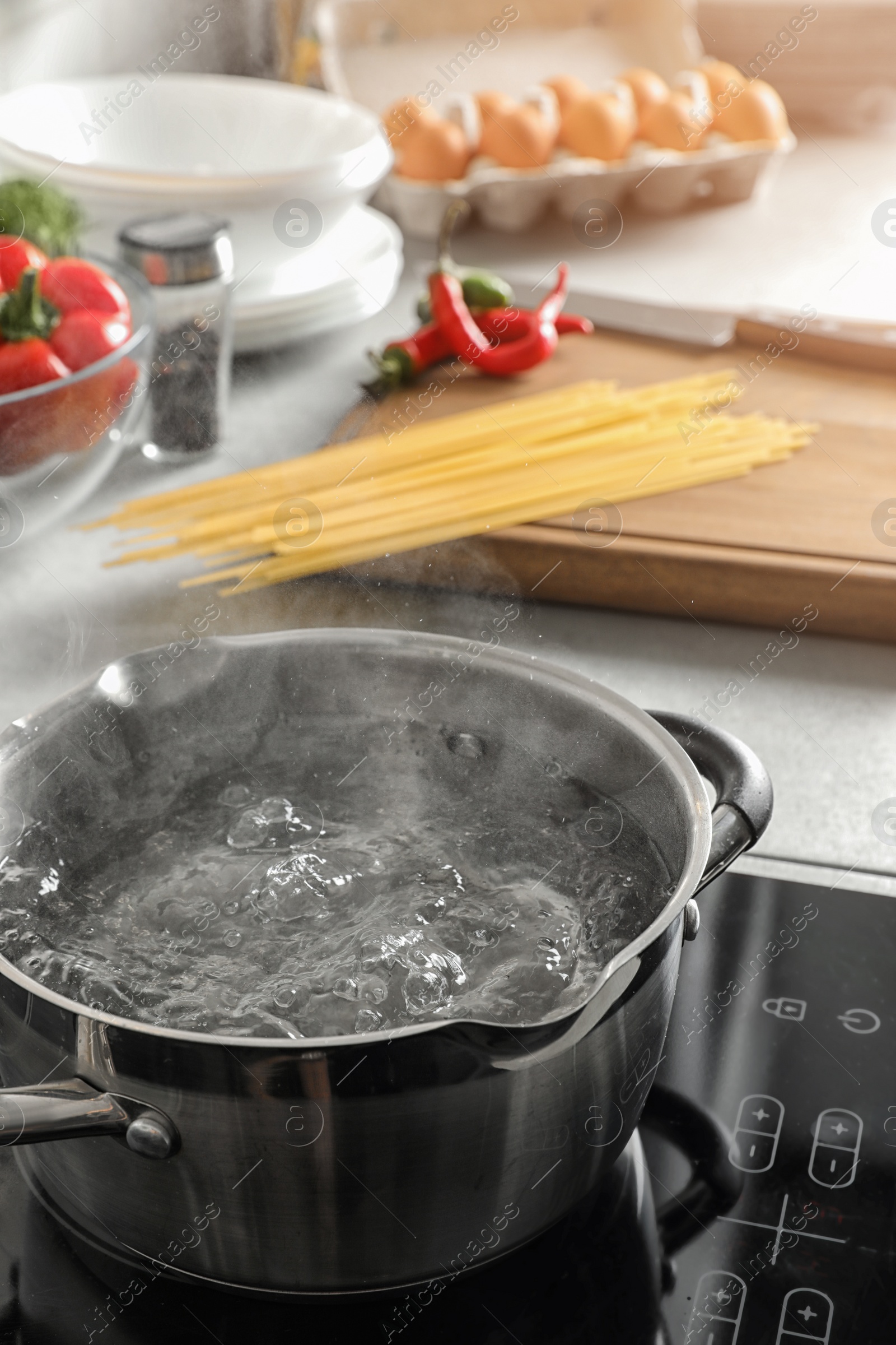 Photo of Pot with boiling water on electric stove in kitchen