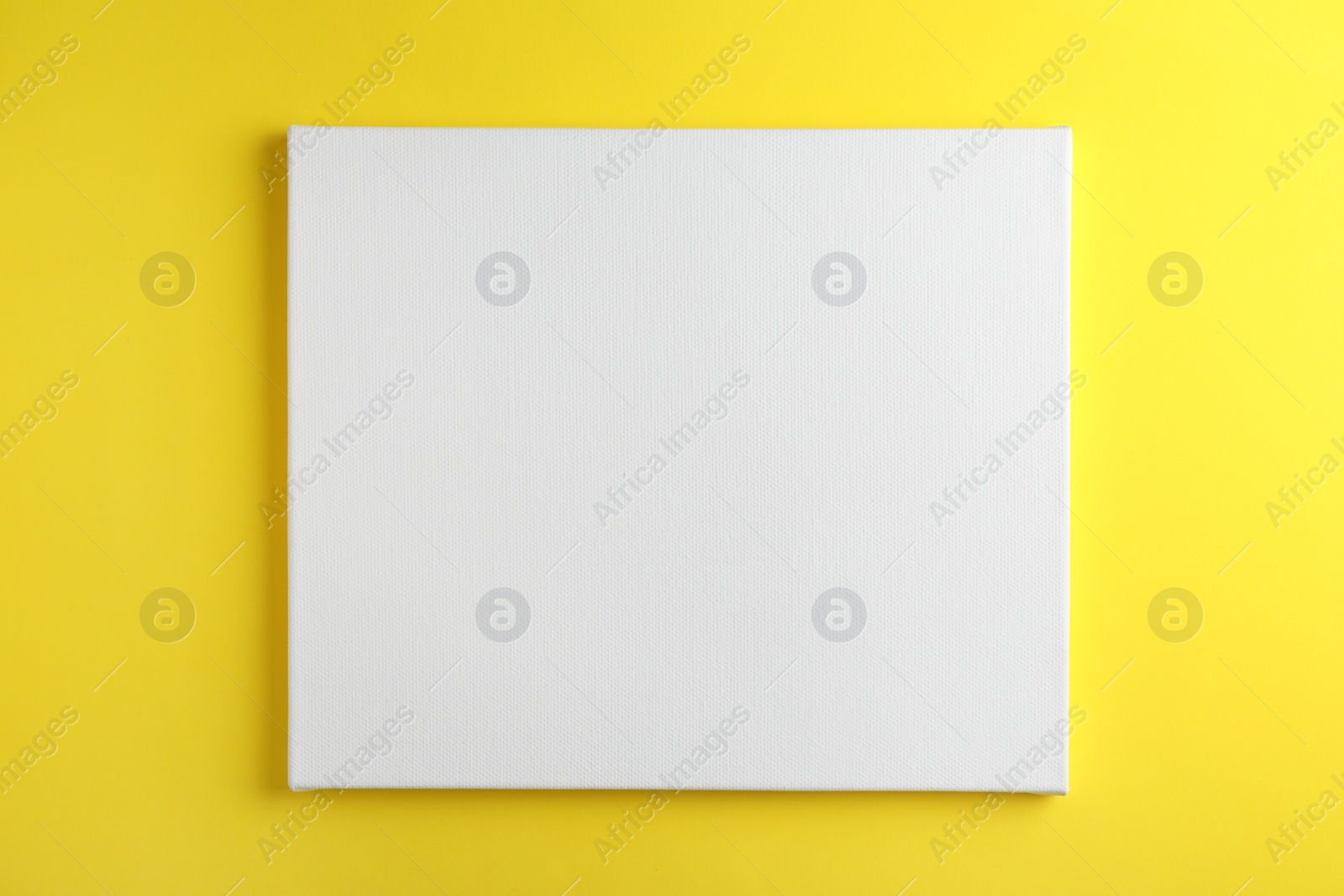 Photo of Blank canvas on yellow background, space for text