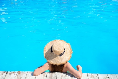 Photo of Young woman in swimming pool on sunny day