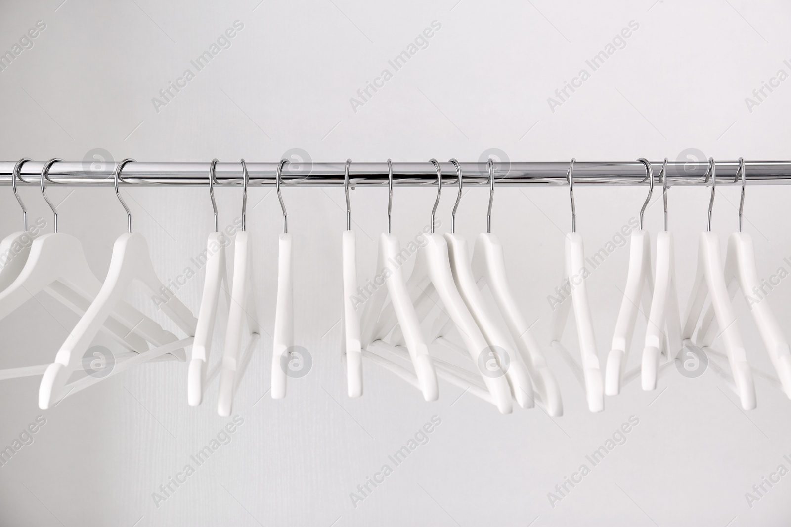 Photo of Clothes rail with hangers on white background