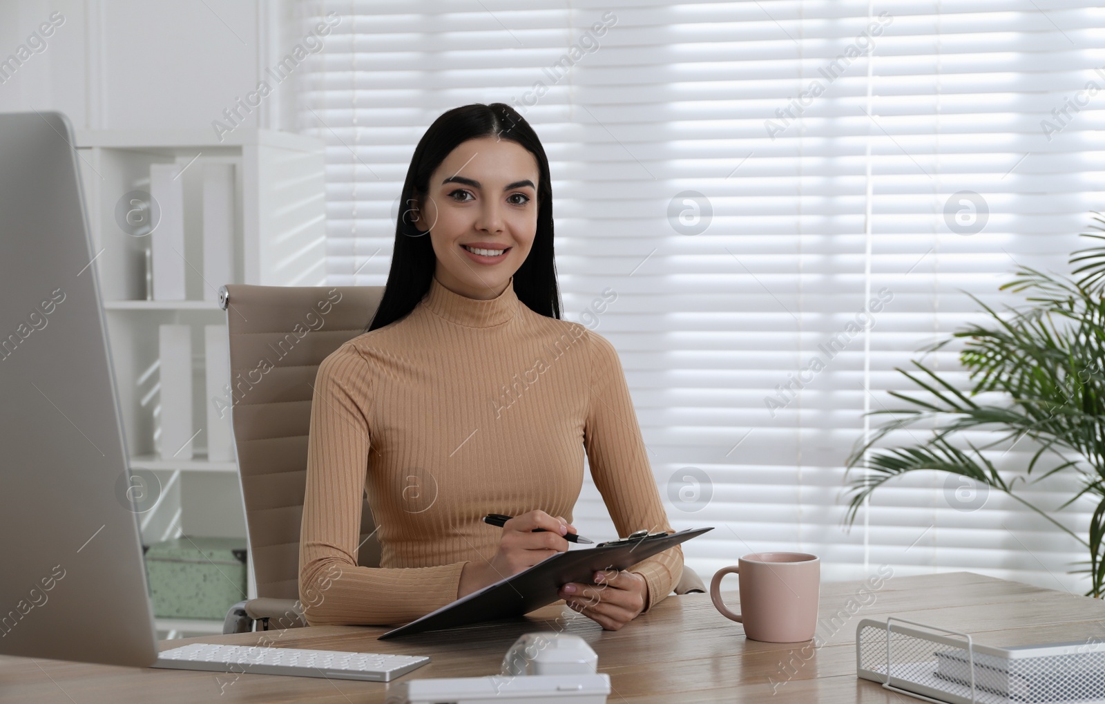 Photo of Secretary working at wooden table in office