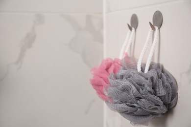 Photo of Shower puffs hanging near faucet in bathroom, space for text