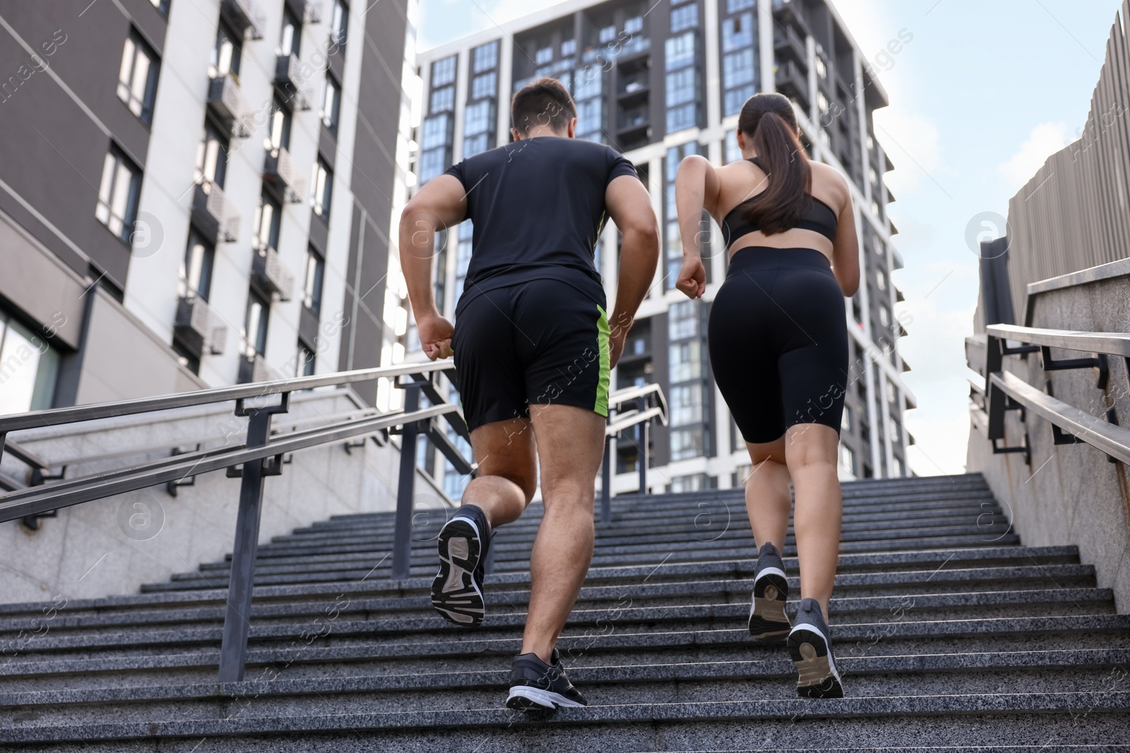 Photo of Healthy lifestyle. Couple running up steps outdoors, low angle view