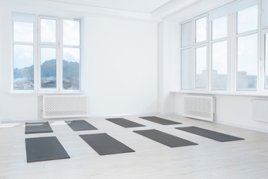 Spacious yoga studio with exercise mats and big windows