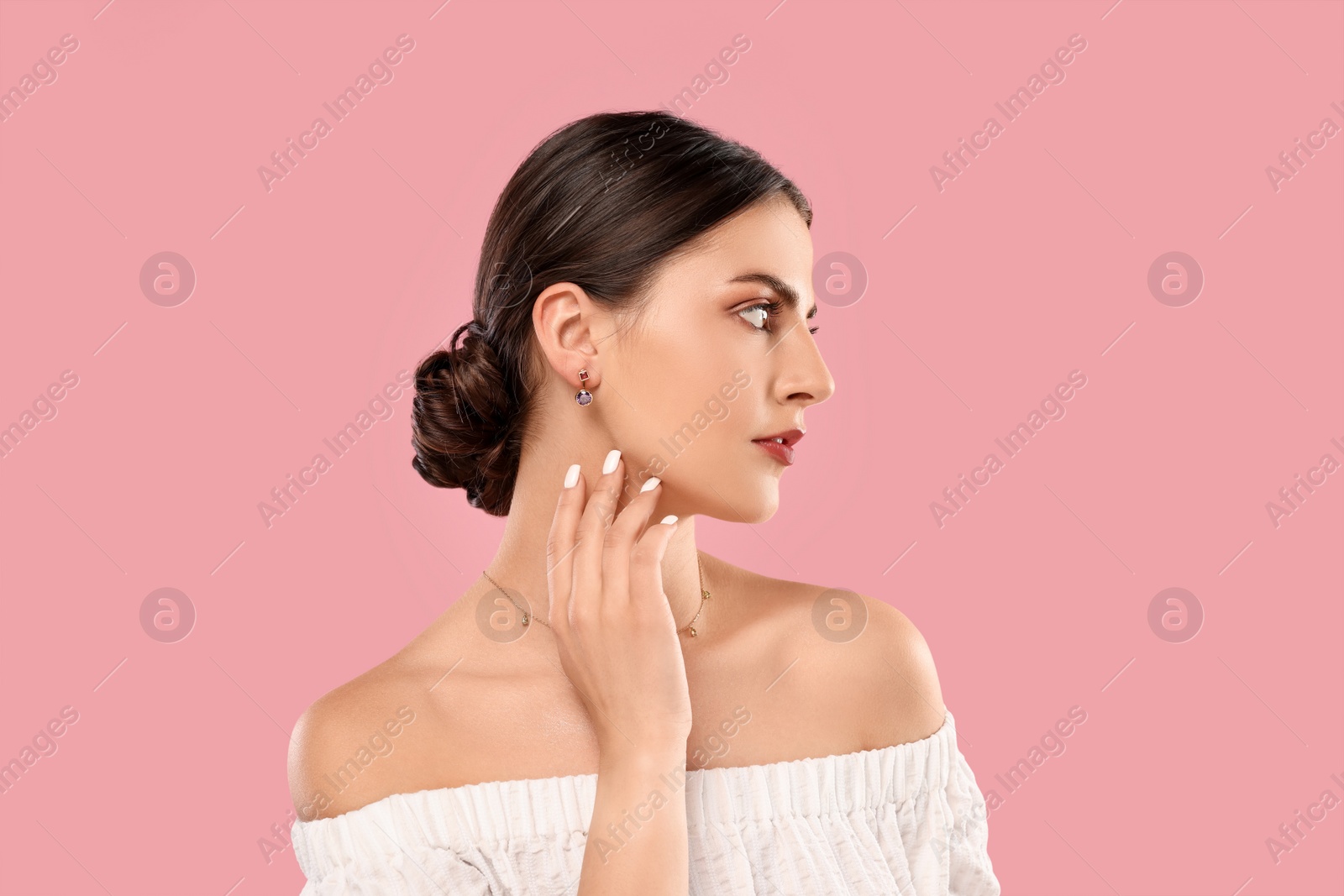 Photo of Beautiful woman with elegant jewelry on pink background, space for text