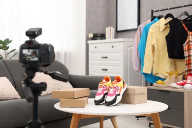 Photo of Fashion blogger's workplace. Shoes, clothes, camera and stylish furniture indoors