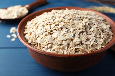 Photo of Bowl of oatmeal on blue wooden table, closeup