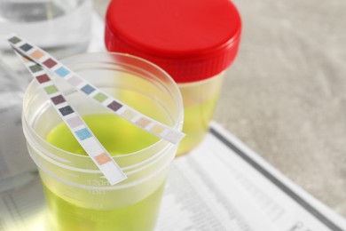 Photo of Containers with urine samples for analysis on test forms, closeup