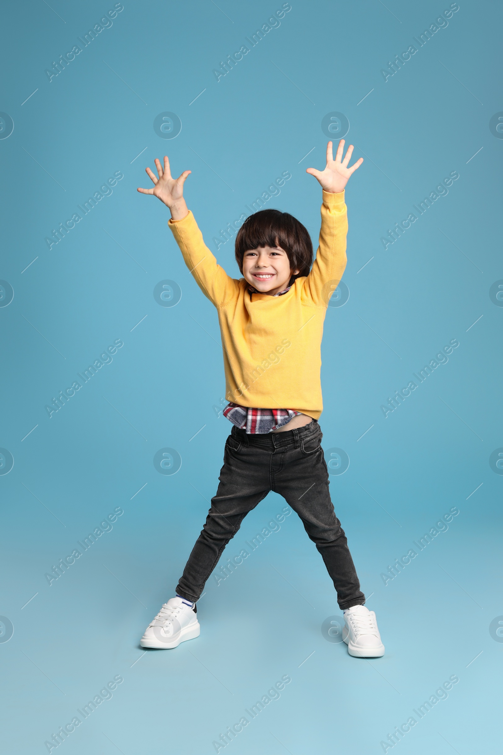 Photo of Full length portrait of cute little boy on light blue background