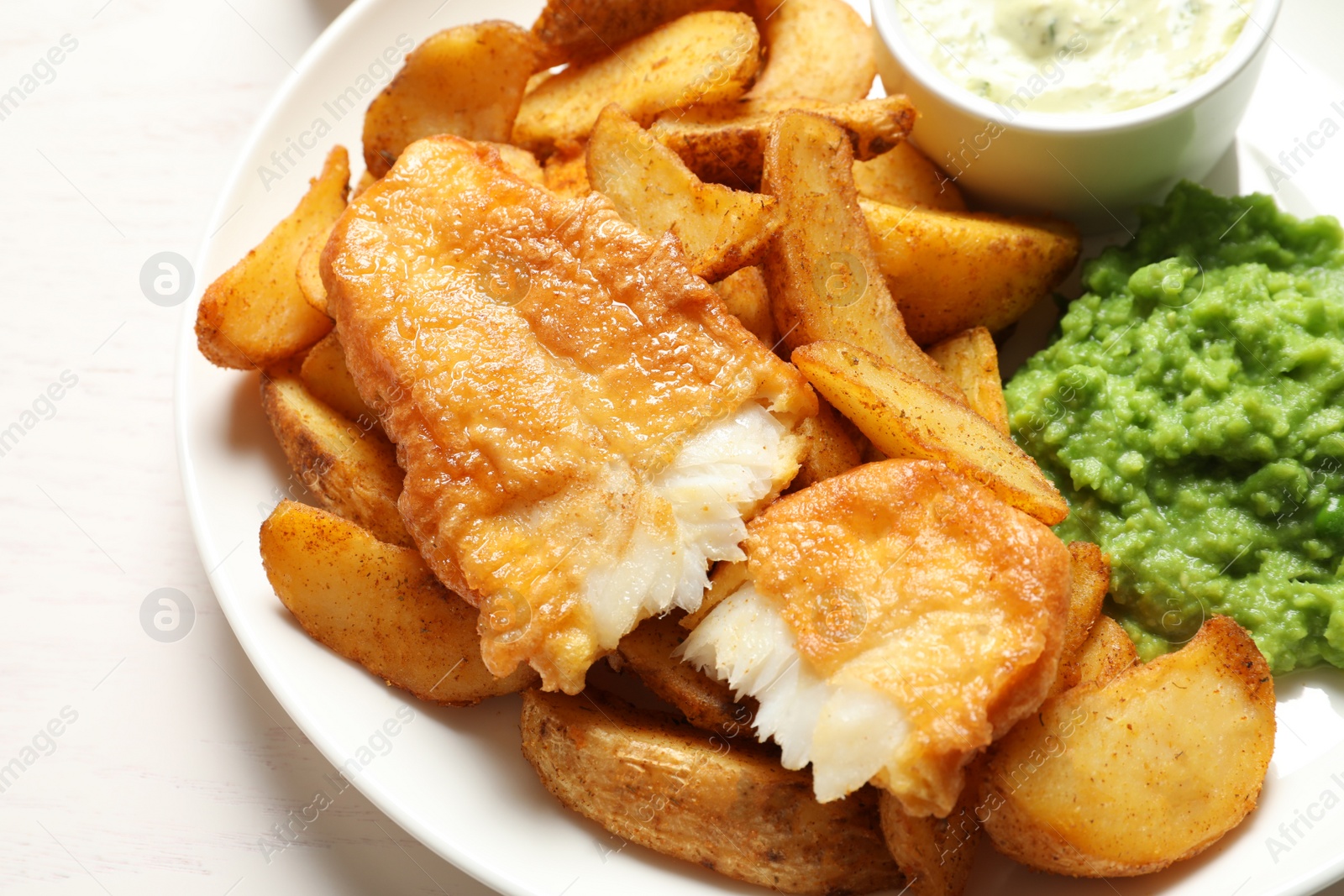 Photo of British Traditional Fish and potato chips on table, closeup