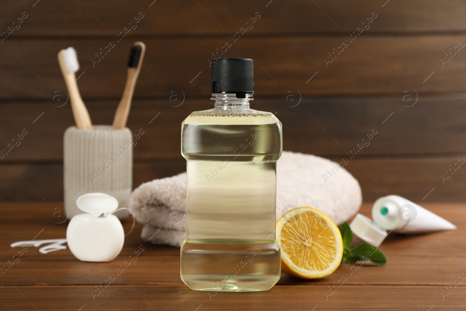 Photo of Mouthwash and other oral hygiene products on wooden table