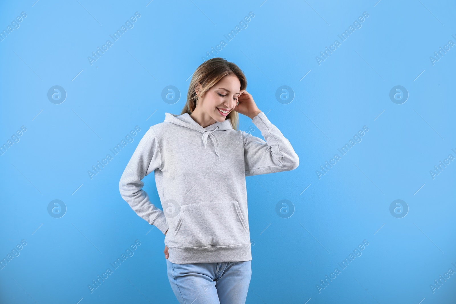 Photo of Portrait of woman in hoodie sweater on color background. Space for design