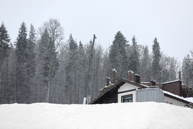 Photo of Cozy cottage on snowy hill. Winter vacation