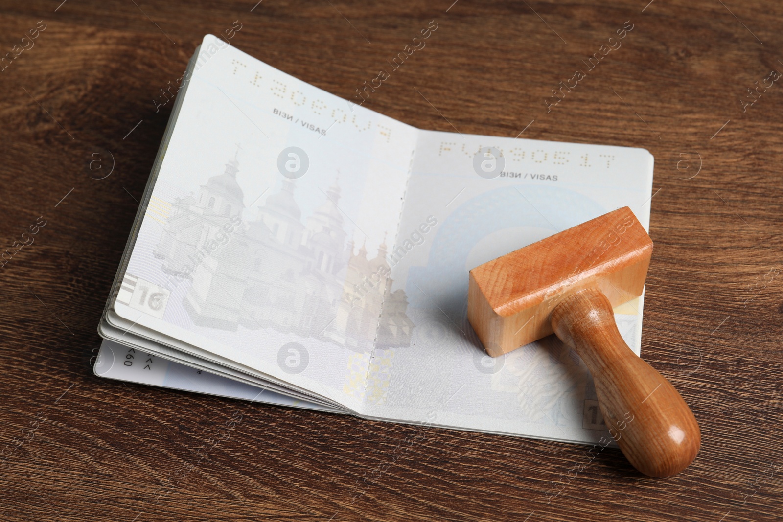 Photo of Ukraine, Lviv - September 6, 2022: Passport and visa stamp on wooden table, closeup