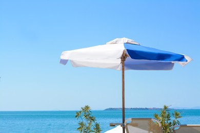 Blue and white beach umbrella at tropical resort