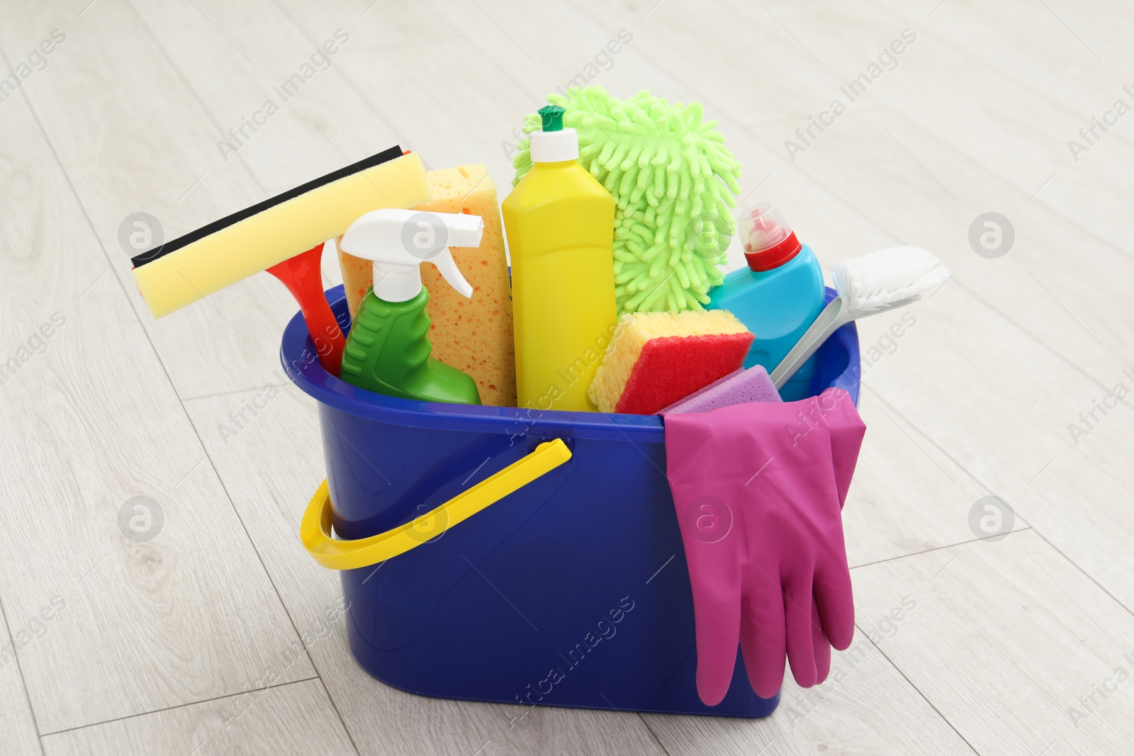 Photo of Different cleaning supplies in bucket on floor