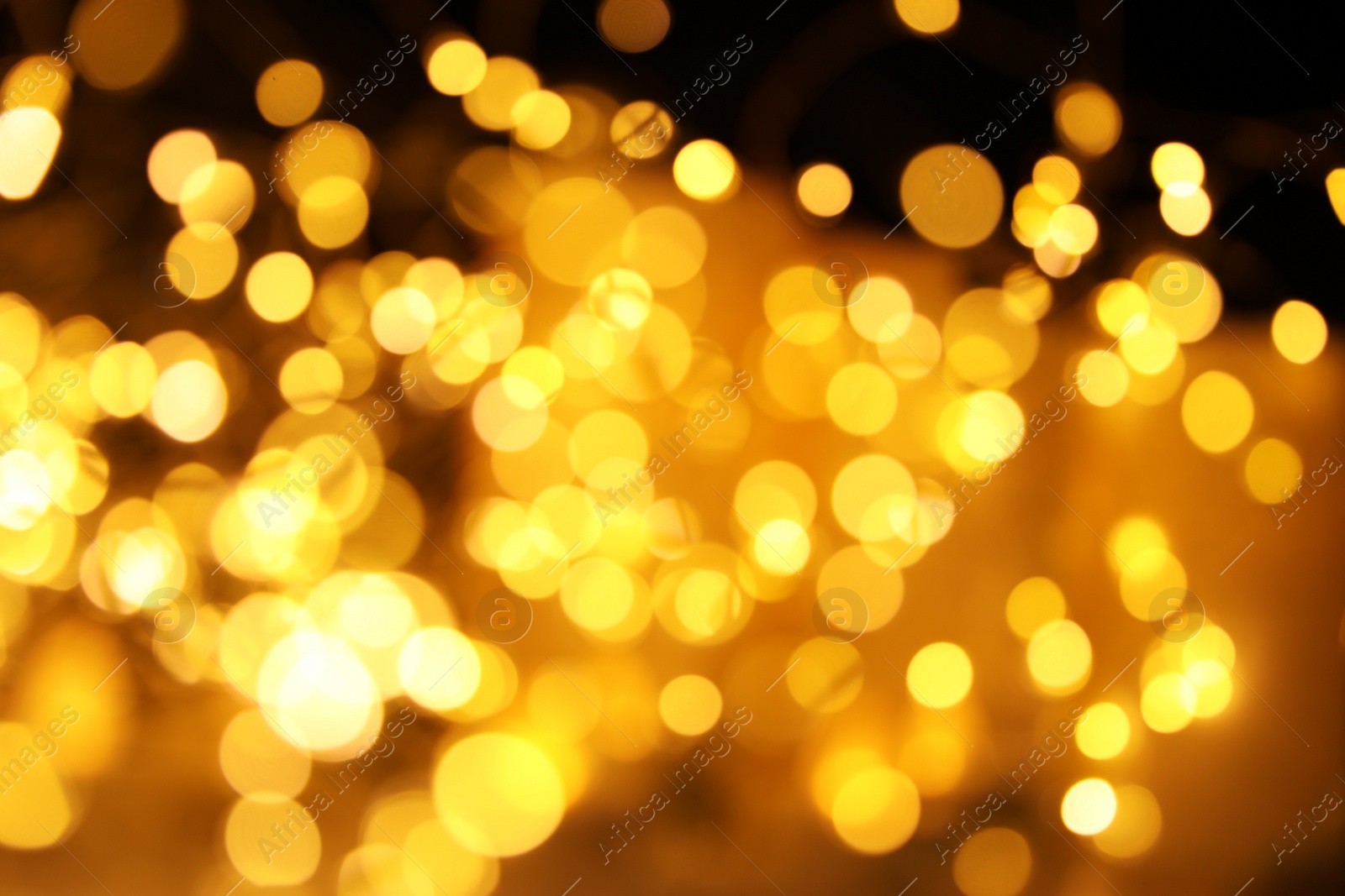 Photo of Gold glitter with bokeh effect on dark background