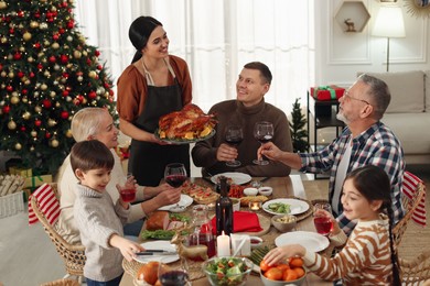 Photo of Happy family enjoying festive dinner at home. Christmas celebration