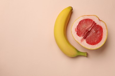 Photo of Banana and half of grapefruit on beige background, flat lay with space for text. Sex concept
