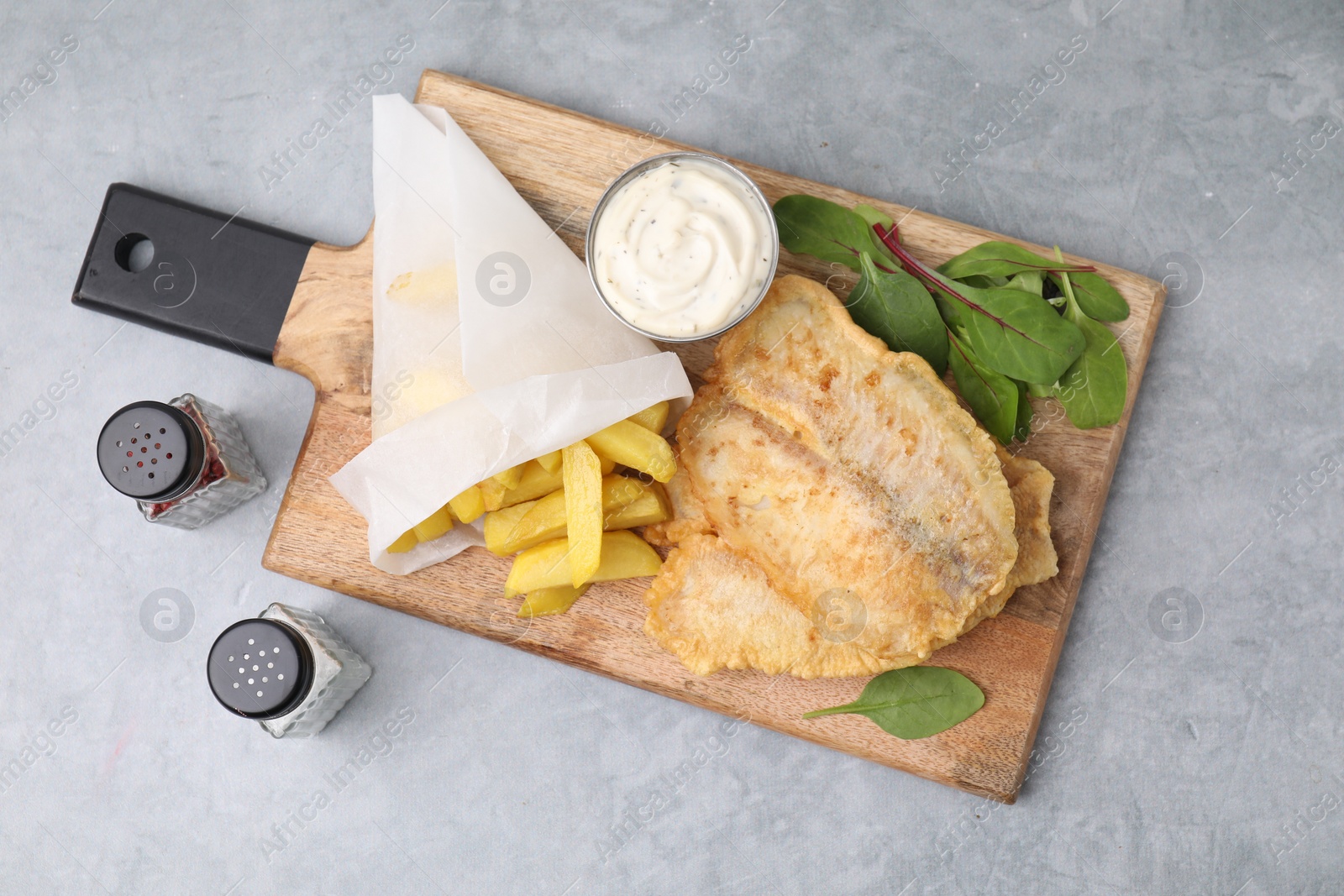 Photo of Delicious fish and chips with tasty sauce, mangold and spices on gray table, top view