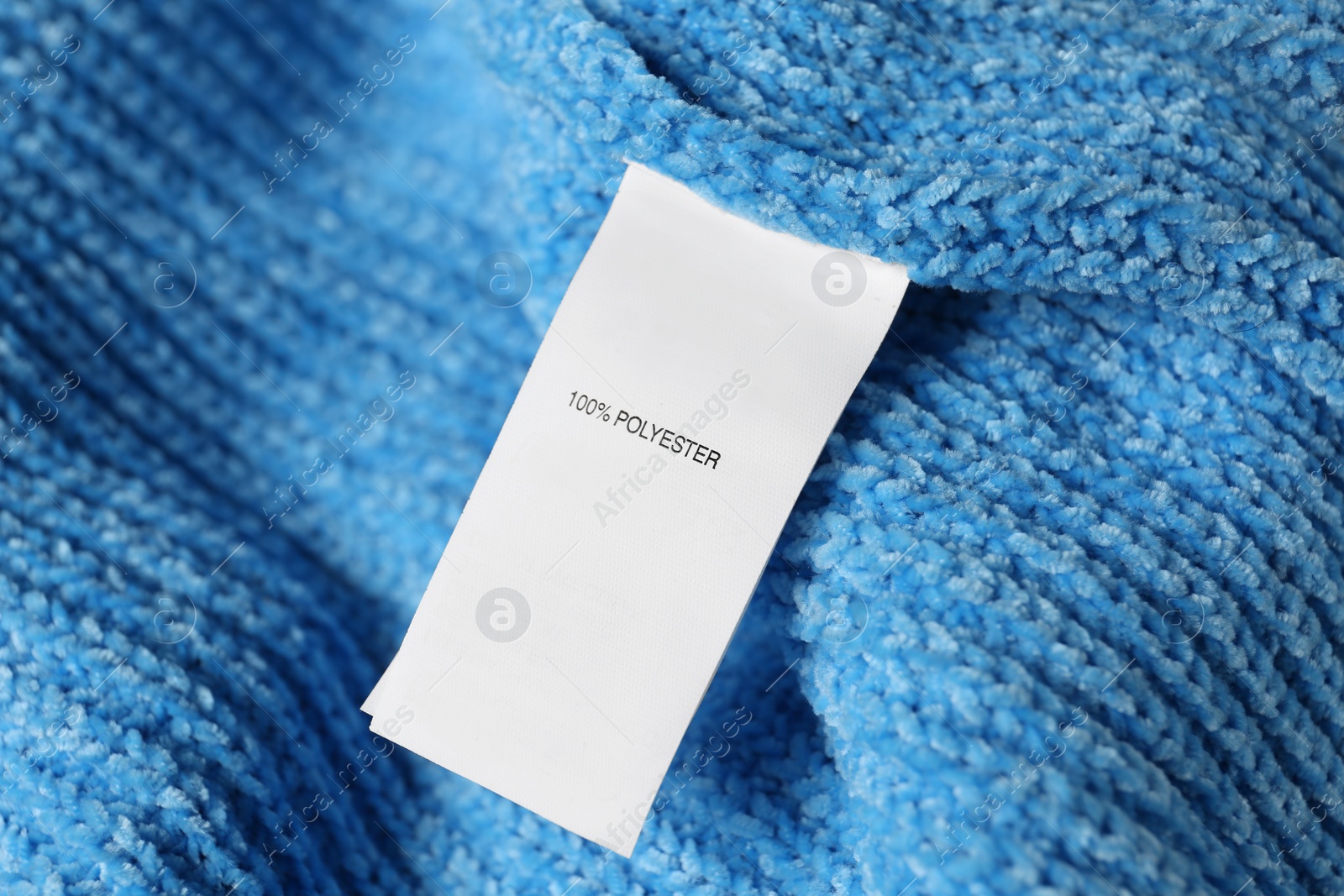 Photo of Clothing label with material content on blue sweater, closeup view