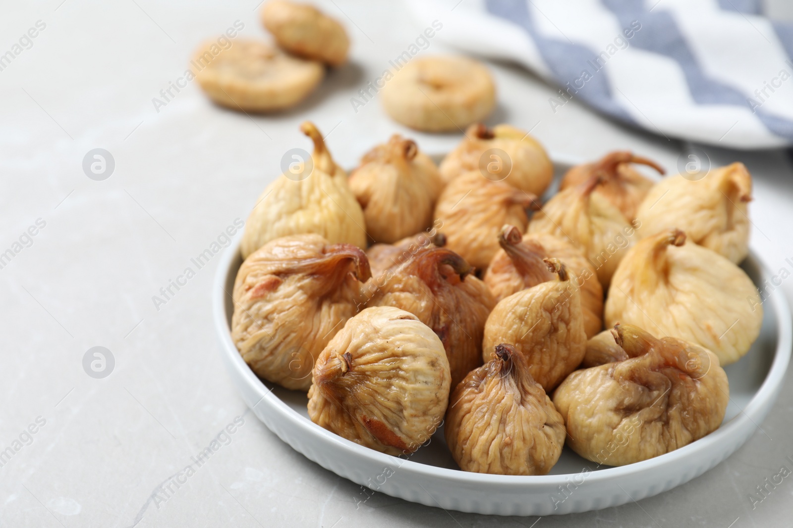 Photo of Tasty dried figs on light grey table, closeup