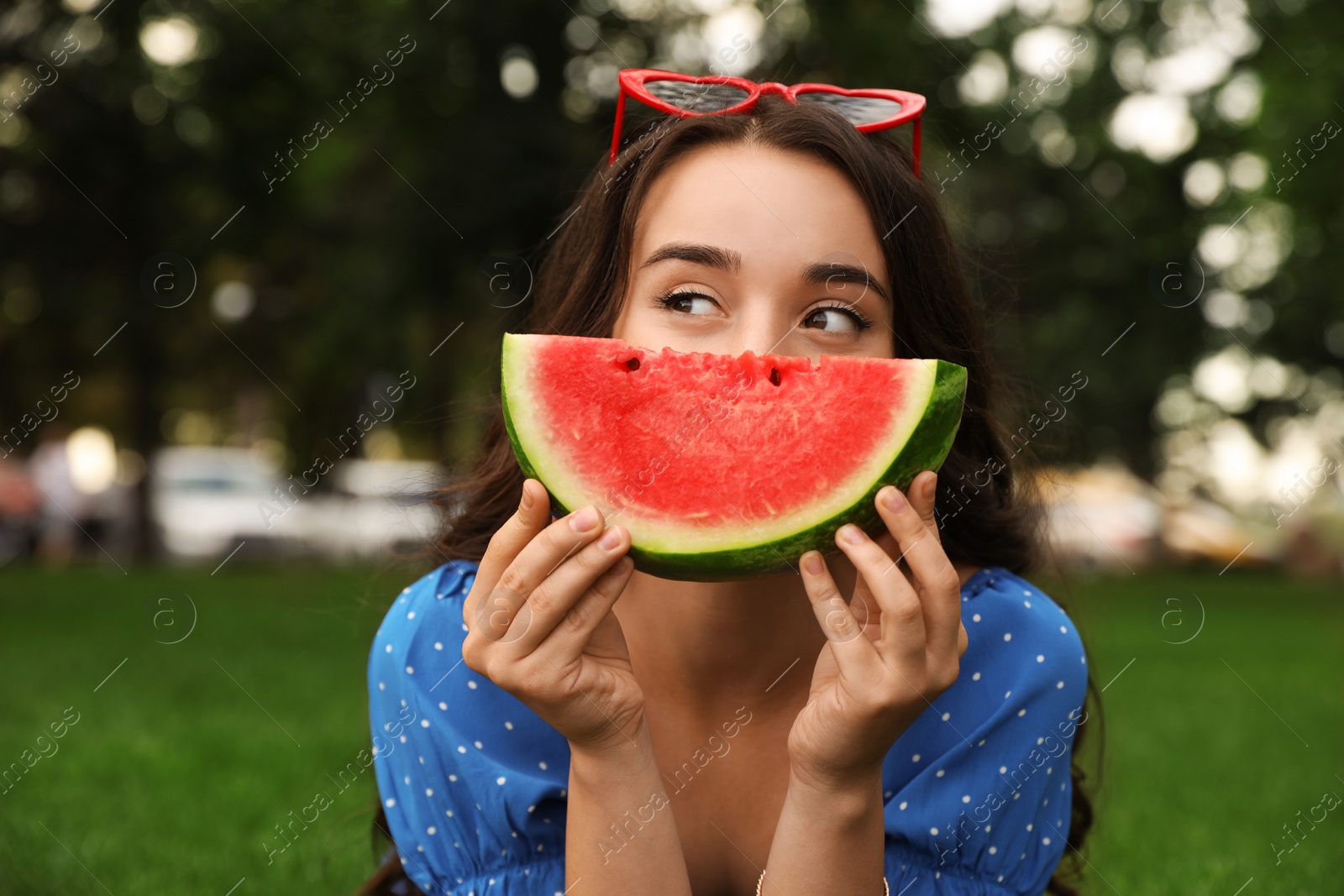 Photo of Beautiful young woman with watermelon in park on sunny day