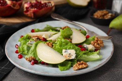 Photo of Delicious pear salad on dark textured table, closeup