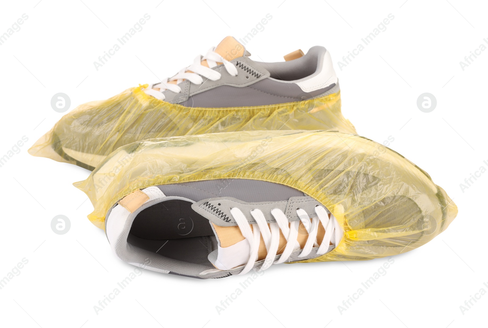 Photo of Men's sneakers in yellow shoe covers isolated on white