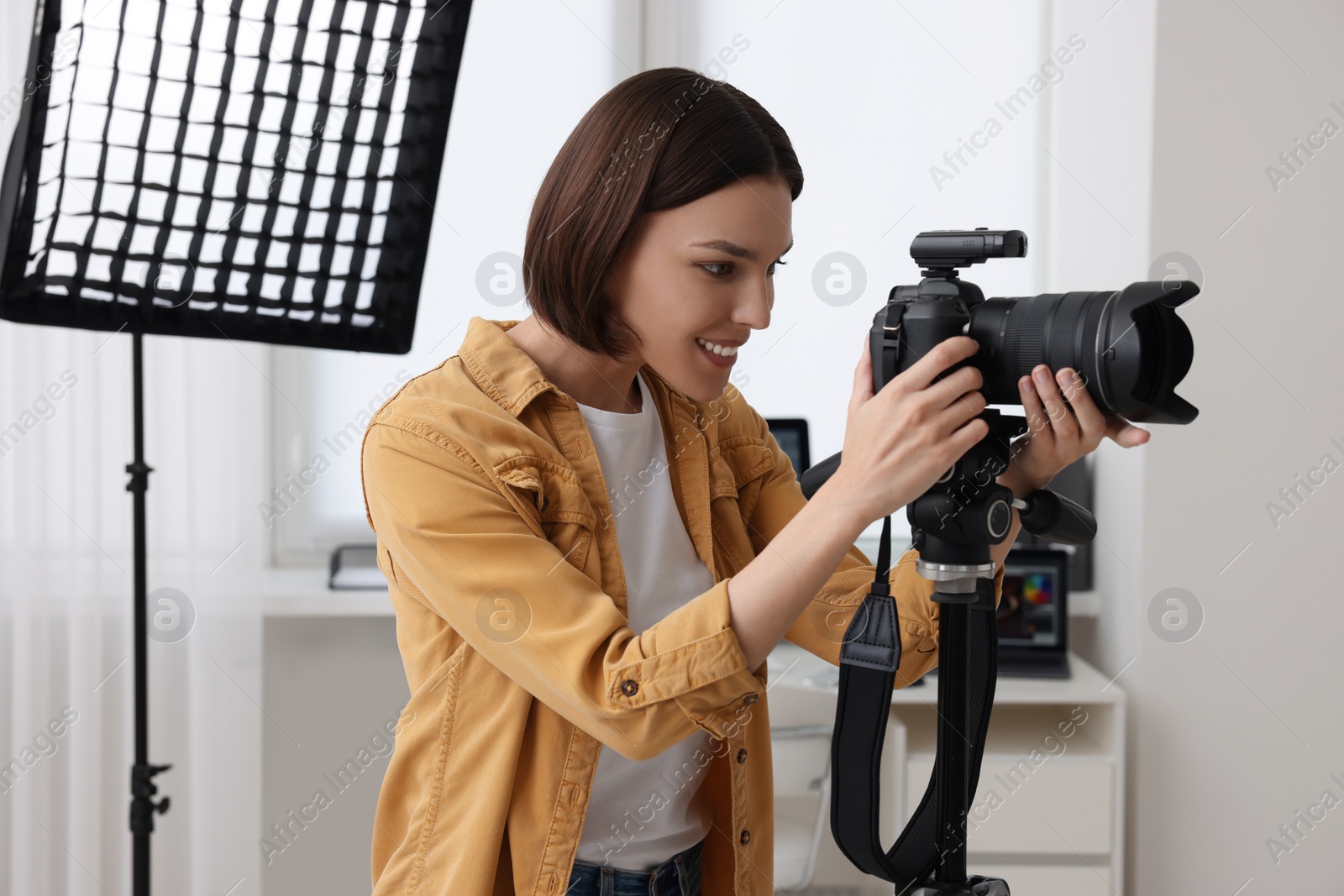 Photo of Professional photographer working with camera in modern photo studio