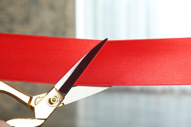 Photo of Ribbon and scissors on blurred background. Ceremonial red tape cutting