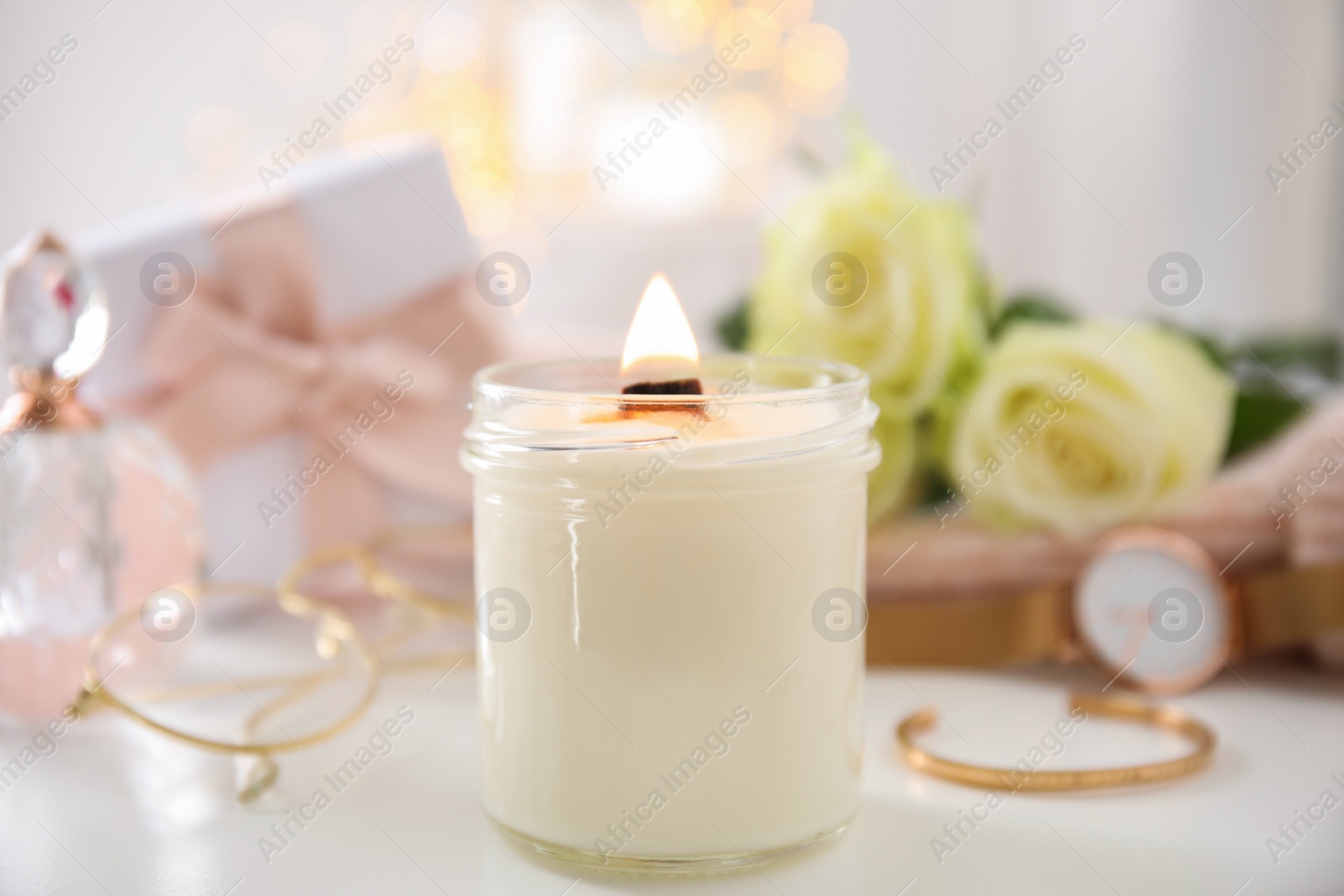 Photo of Burning candle with wooden wick on white table