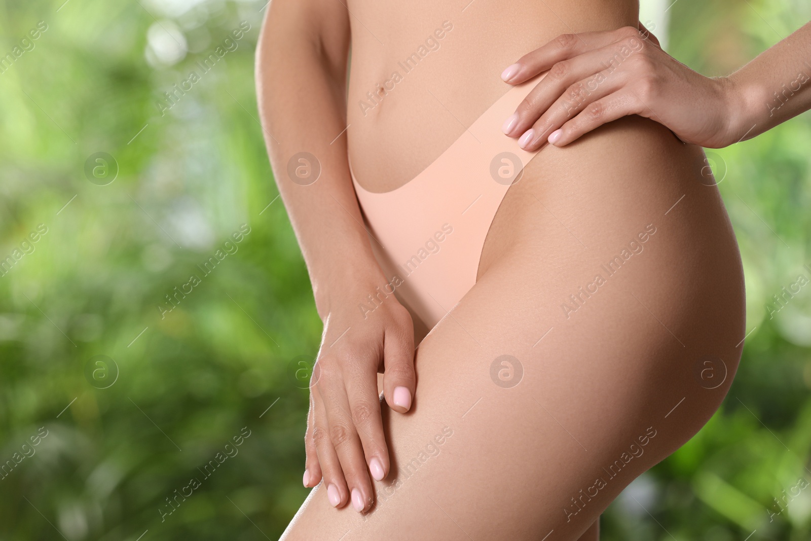 Photo of Closeup view of slim woman in underwear on blurred green background. Cellulite problem concept