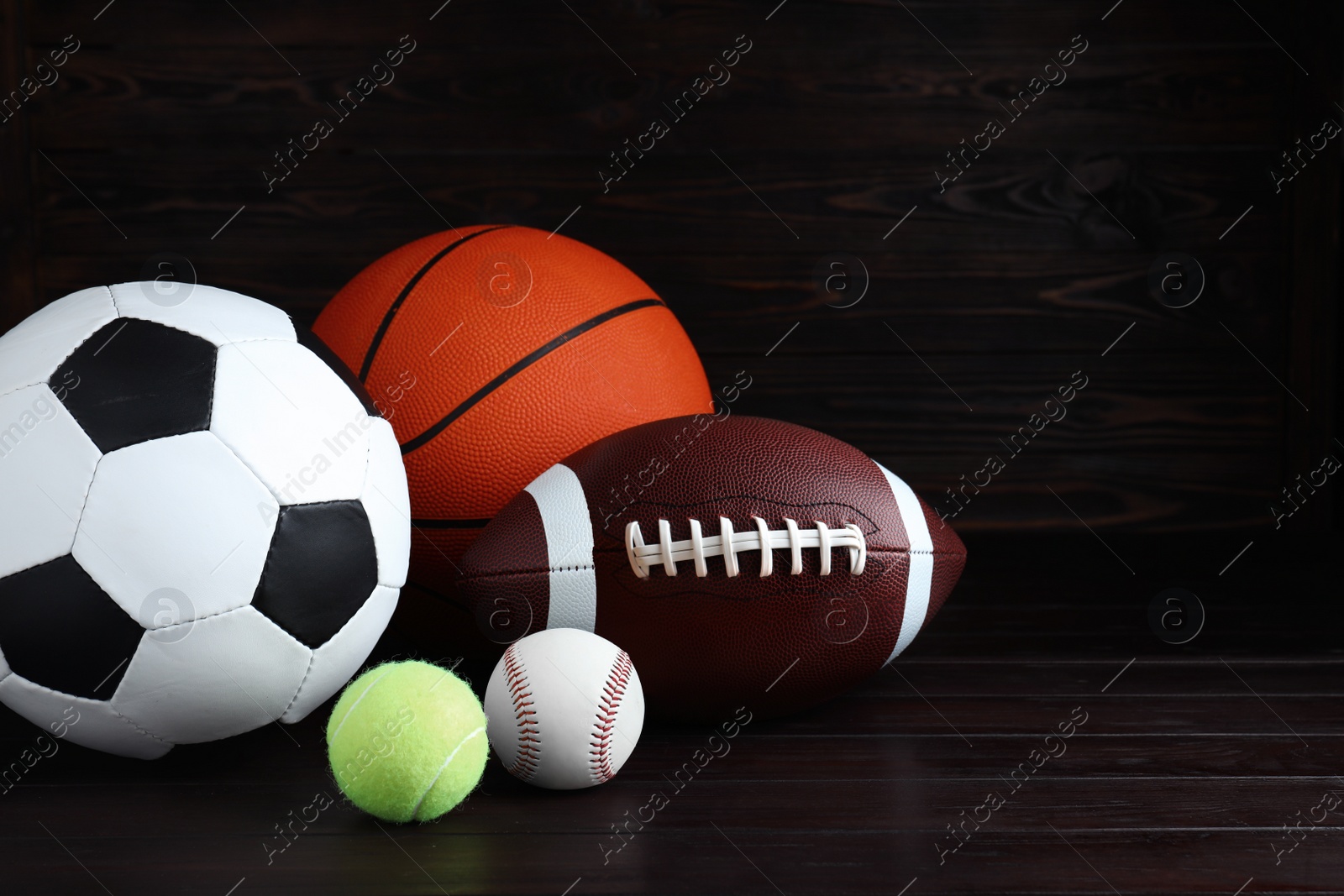 Photo of Set of different sport balls on wooden table. Space for text