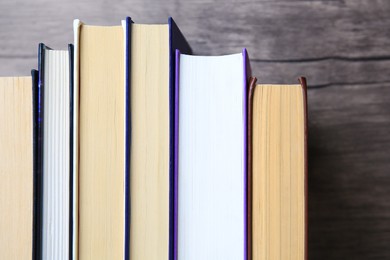 Photo of Collection of different books near wooden wall, closeup