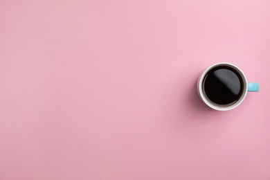 Ceramic cup with hot aromatic coffee on color background, top view