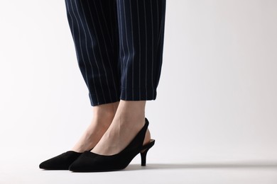 Photo of Businesswoman in black shoes on white background, closeup