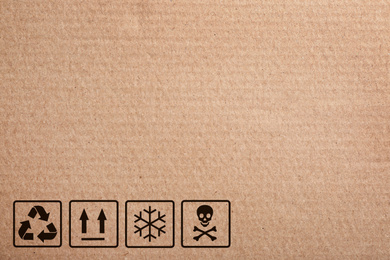 Image of Cardboard box with packaging symbols as background, closeup