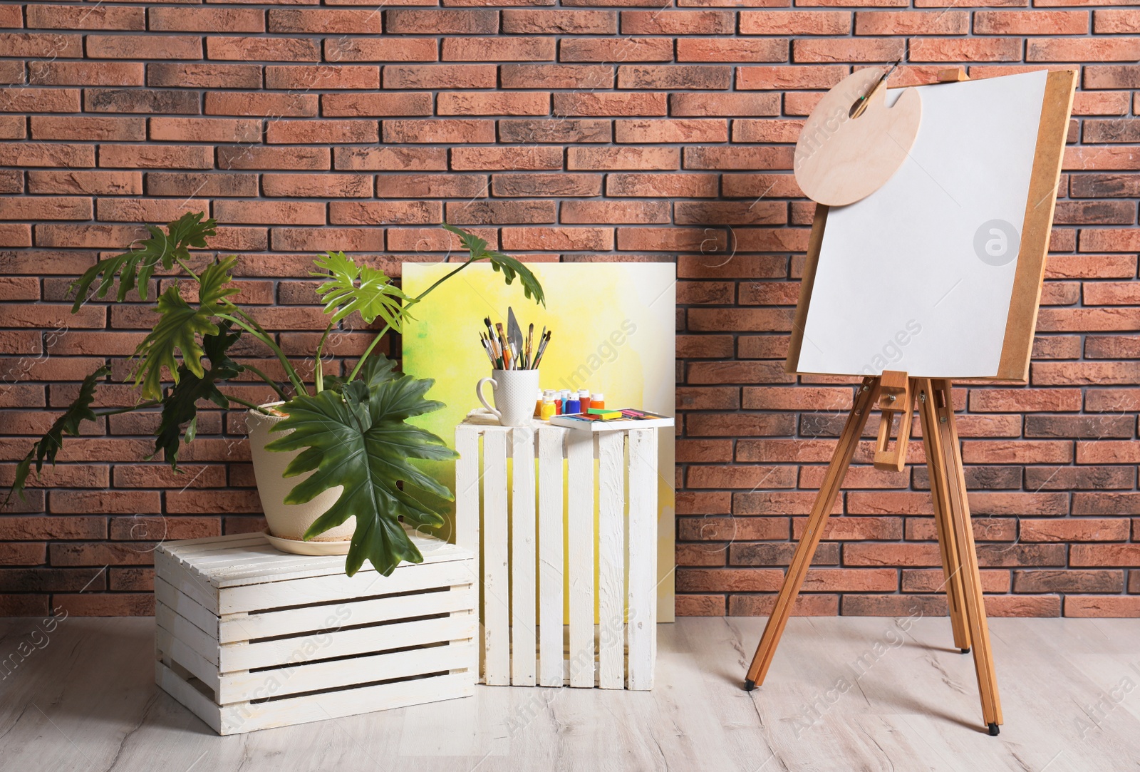 Photo of Artist's workshop interior with easel and set of professional equipment. Space for design