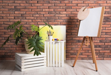 Photo of Artist's workshop interior with easel and set of professional equipment. Space for design