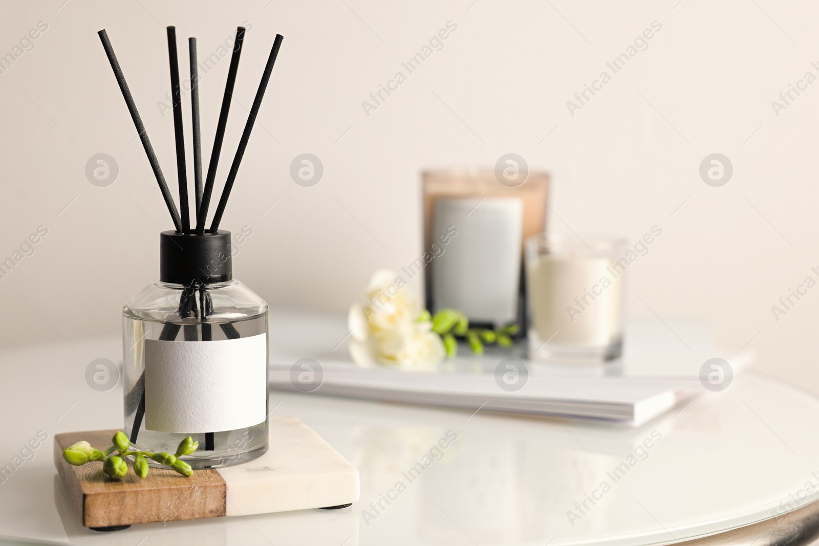 Photo of Aromatic reed air freshener on white table, space for text