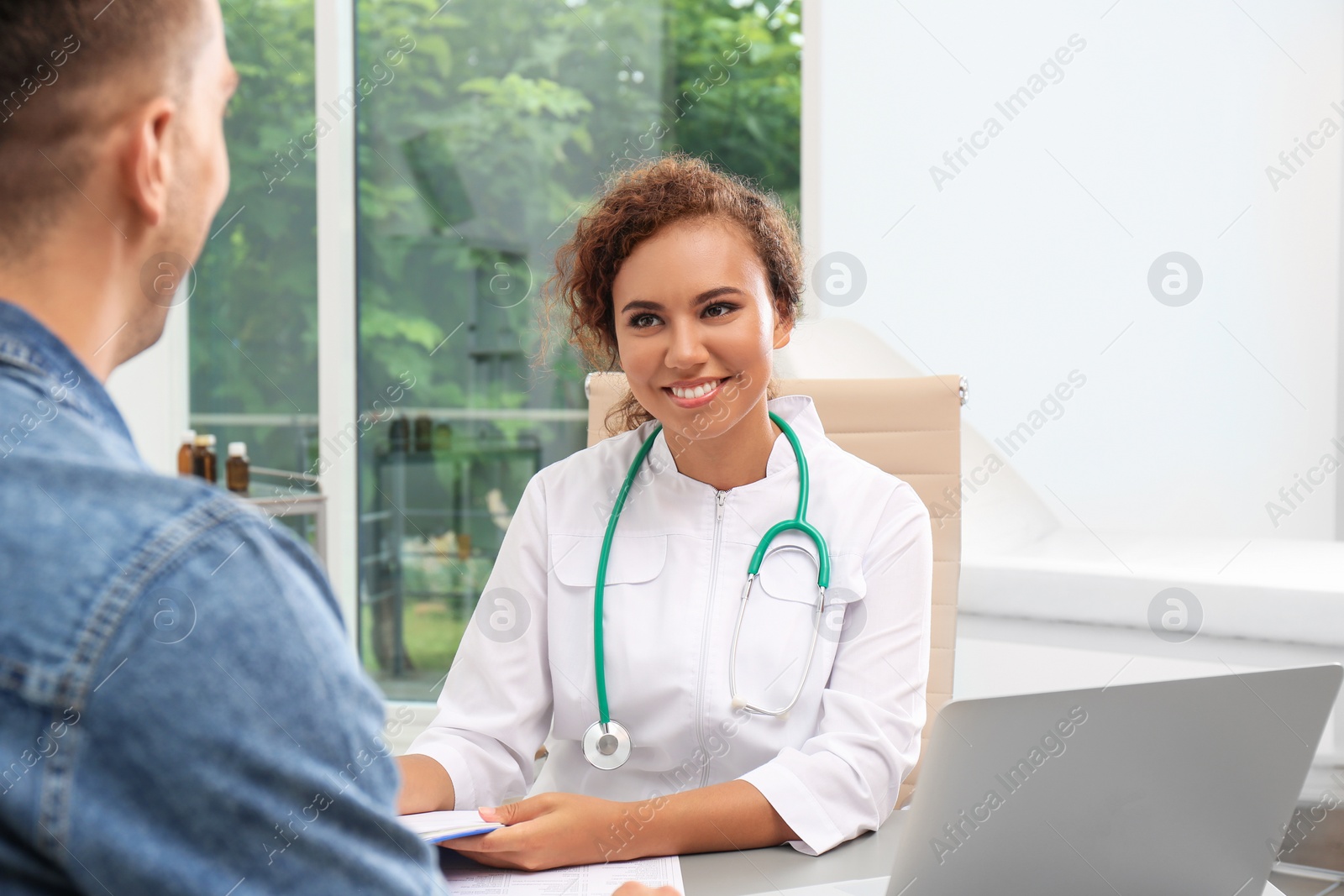 Photo of African American doctor working with patient in hospital