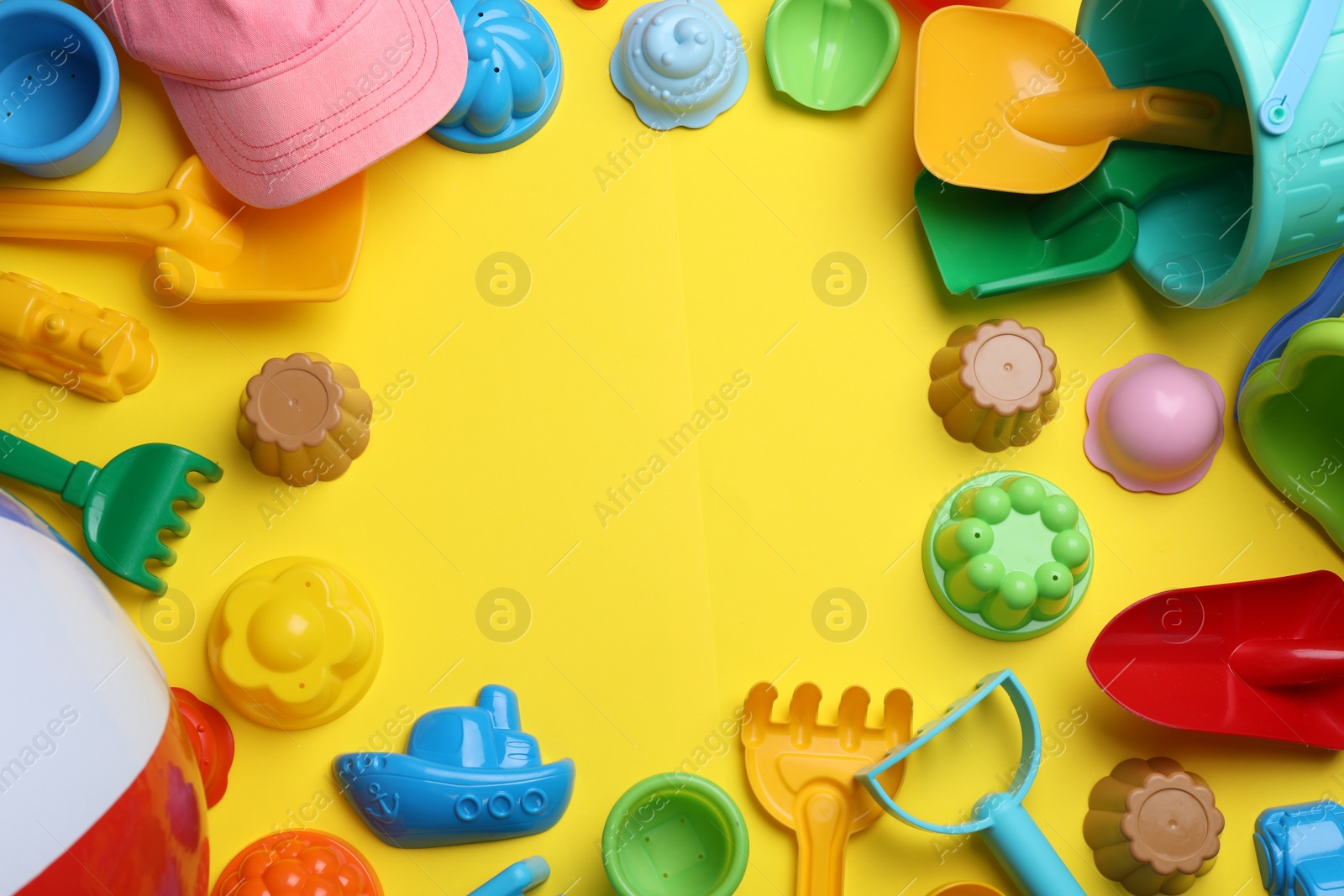 Photo of Frame of beach sand toys on yellow background, flat lay. Space for text