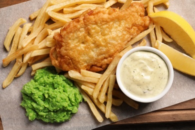 Photo of British traditional fish and potato chips on table, top view